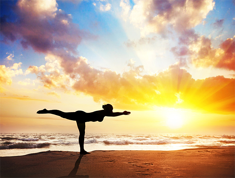 woman in yoga pose on beach